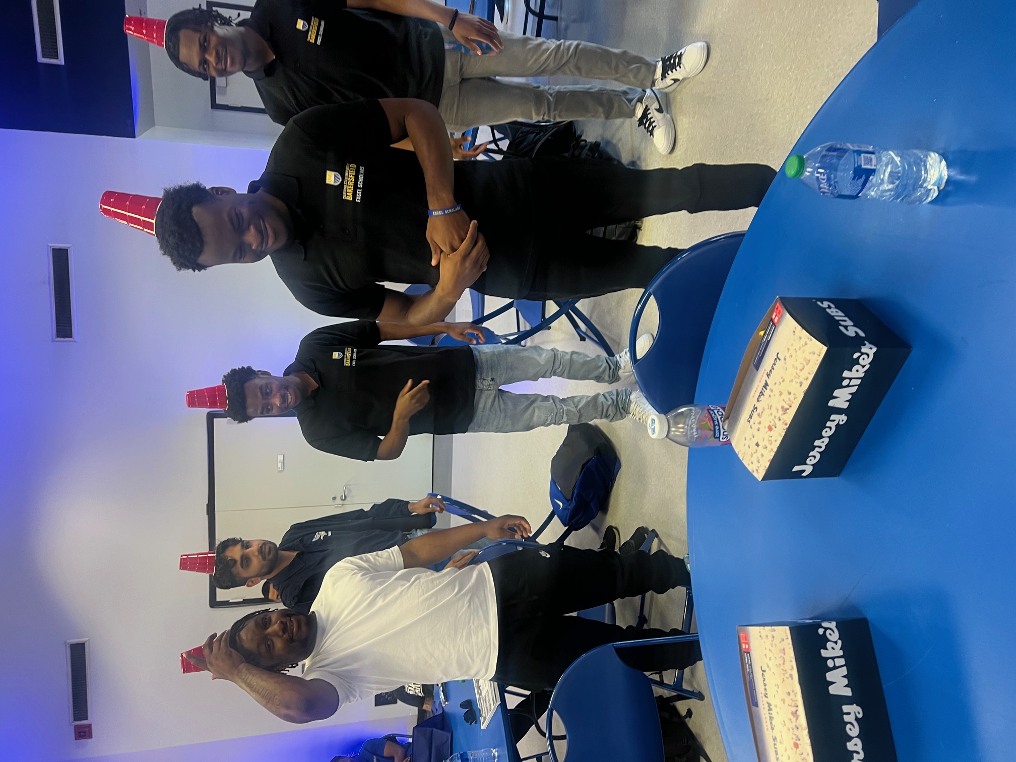 Group with cups on head at Rise event.