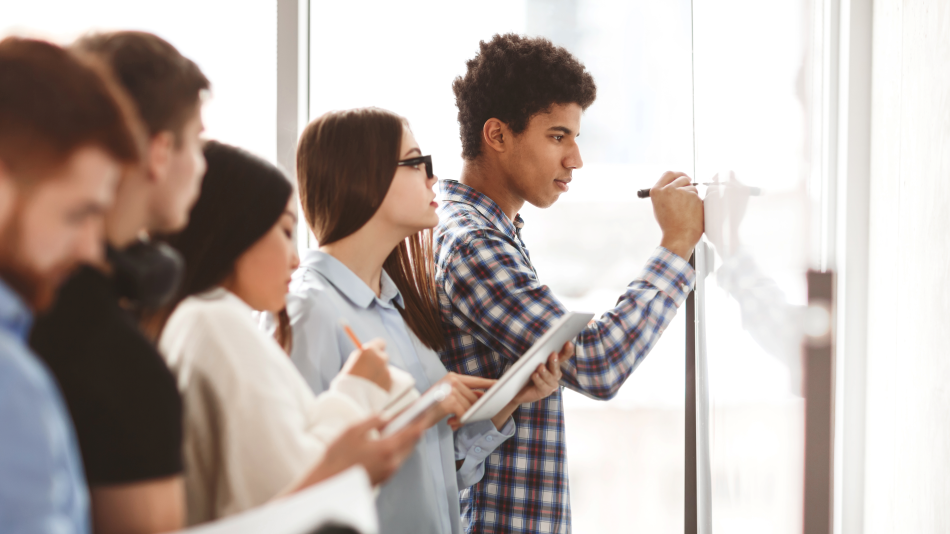 a group of diverse students engage in a whiteboard activity